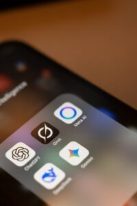 Smartphone screen displays ai app icons: chatgpt, grok, meta ai, gemini.